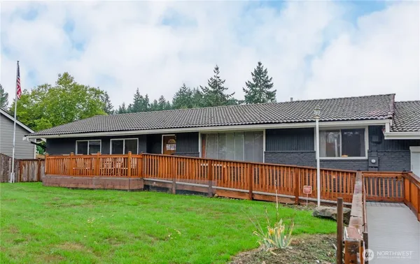 a backyard of a house with wooden fence and large trees