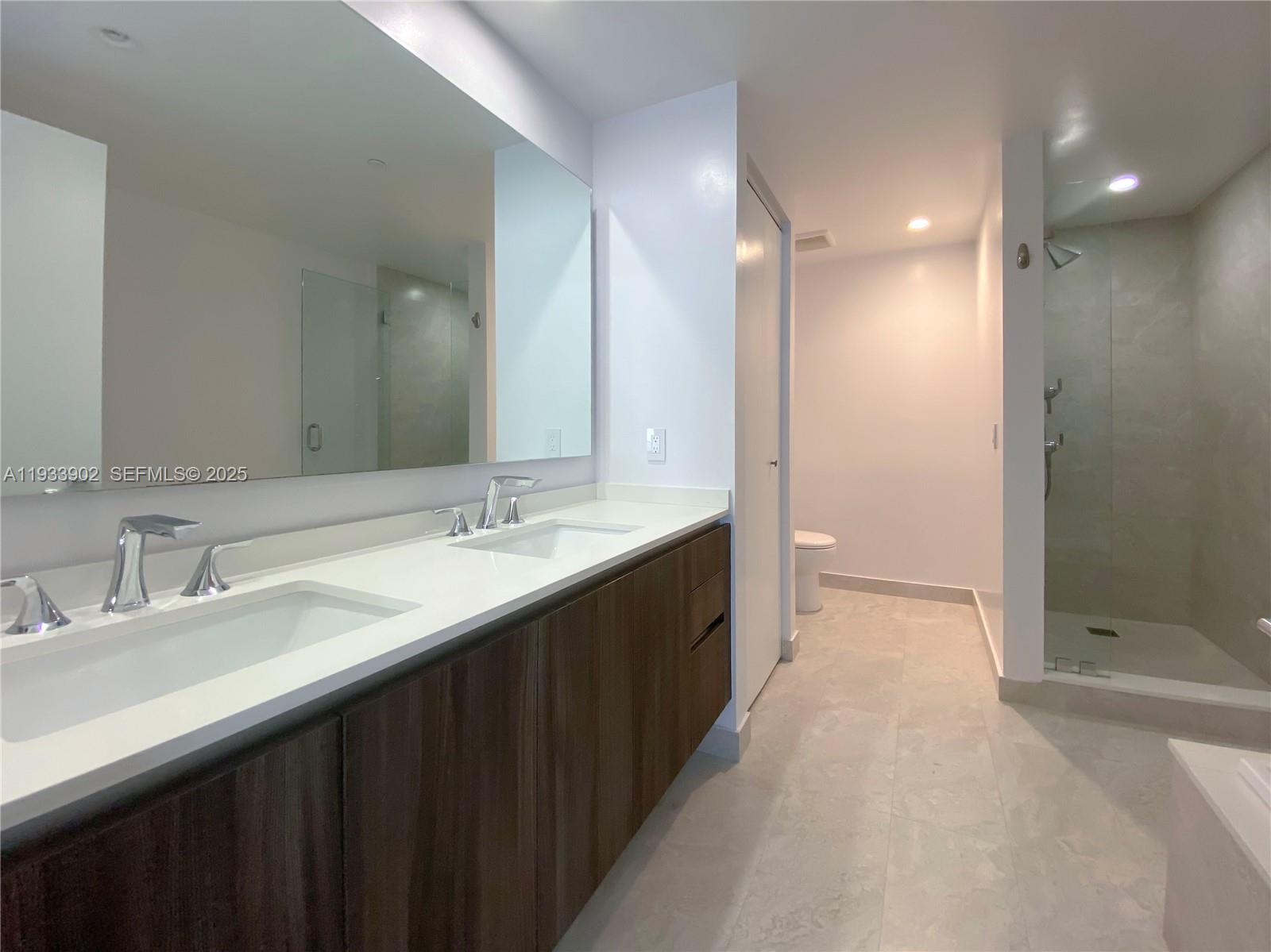 488 Northeast 18th Street, Unit 2610 Miami, FL 33132 - Photo 12 of 21 a bathroom with a double vanity sink mirror and shower