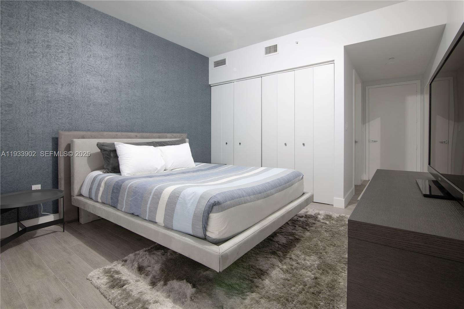 488 Northeast 18th Street, Unit 2610 Miami, FL 33132 - Photo 17 of 21 a bedroom with a bed and a flat screen tv