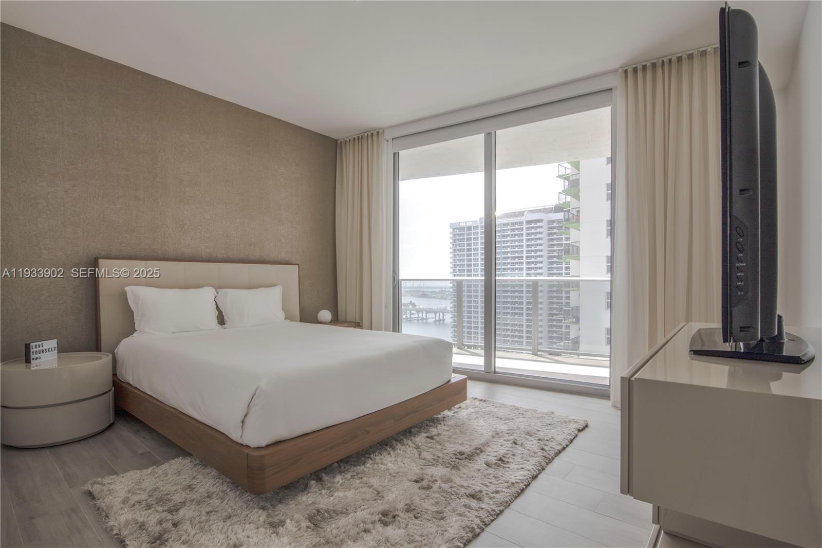 488 Northeast 18th Street, Unit 2610 Miami, FL 33132 - Photo 18 of 21 a bedroom with a bed and glass window