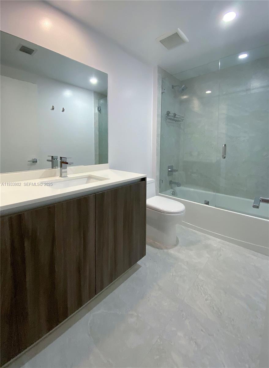 488 Northeast 18th Street, Unit 2610 Miami, FL 33132 - Photo 19 of 21 a bathroom with a double vanity sink toilet and shower