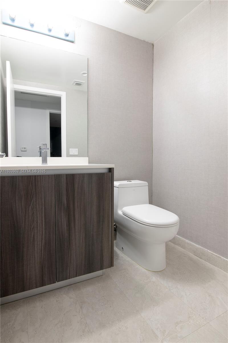 488 Northeast 18th Street, Unit 2610 Miami, FL 33132 - Photo 20 of 21 a white toilet sitting next to a bathroom sink