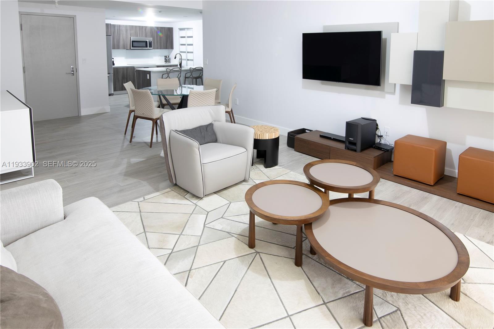 488 Northeast 18th Street, Unit 2610 Miami, FL 33132 - Photo 5 of 21 a living room with furniture a flat screen tv and kitchen view