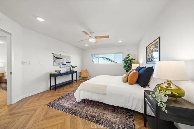 a bedroom with a bed and a lamp on dresser