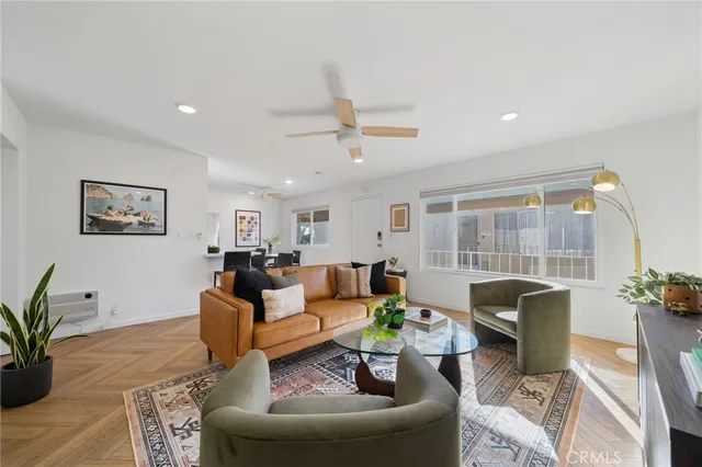 a living room with furniture potted plant and a large window