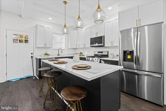 a kitchen that has a lot of cabinets a sink and a refrigerator