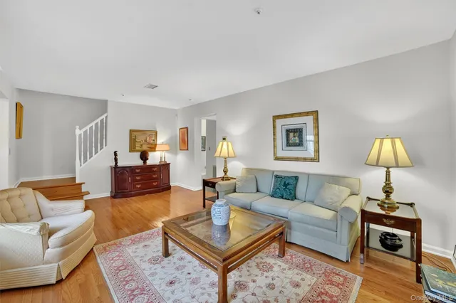 a living room with furniture a rug and a lamp