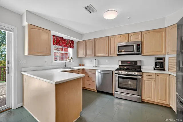 a kitchen with kitchen island a sink stove top oven and microwave