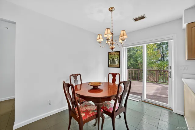 a dining room with furniture a chandelier and window
