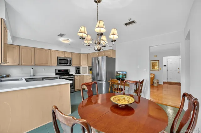 a view of a dining room with furniture a chandelier and wooden floor
