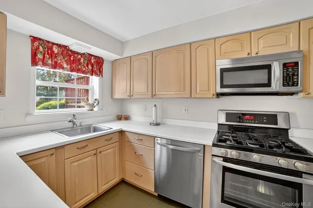 a kitchen with cabinets appliances a sink and a window