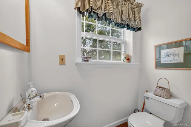 a bathroom with a toilet a sink and mirror