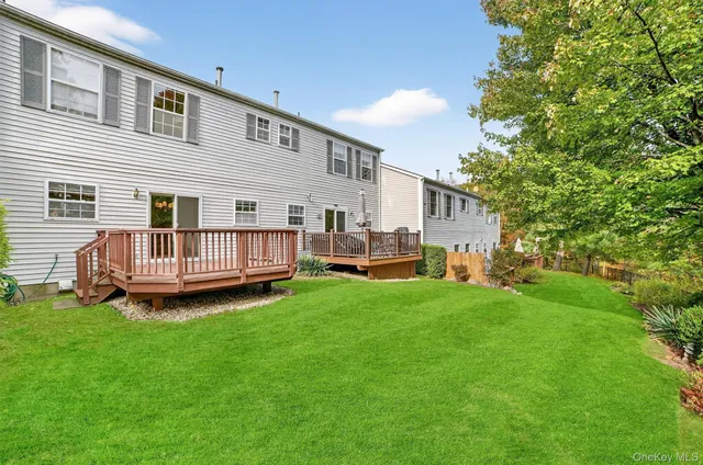 a view of a house with a yard and deck