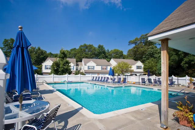 a view of a swimming pool with a patio and a yard
