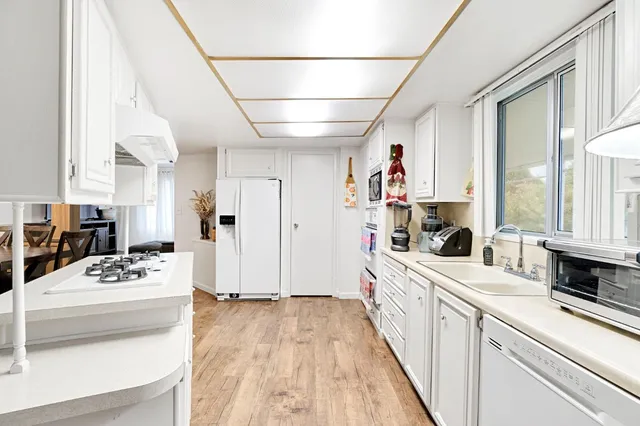 a large white kitchen with sink stove and refrigerator