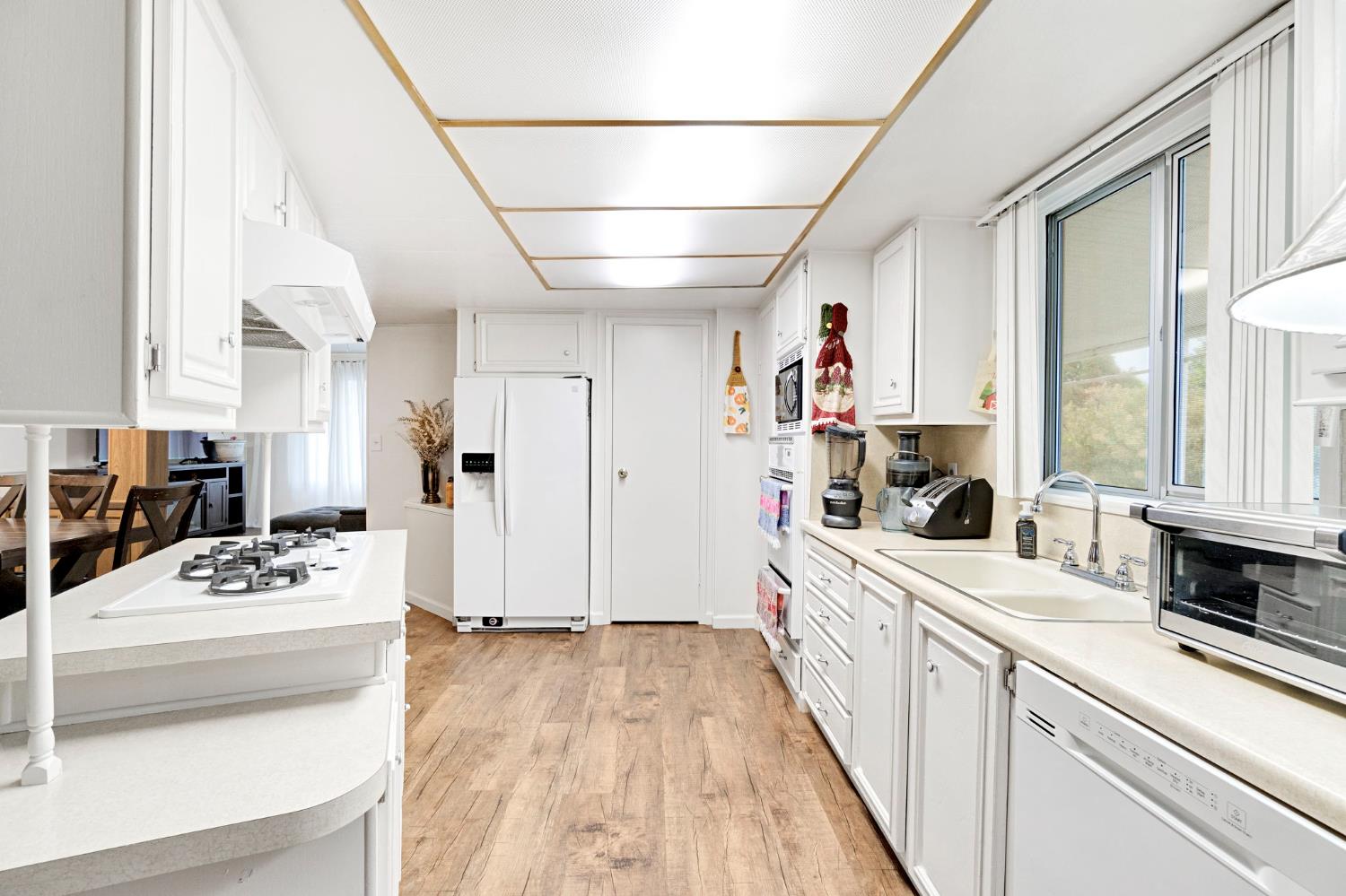 3556 North Duke Avenue, Unit 165 Fresno, CA 93727 - Photo 12 of 25 a large white kitchen with sink stove and refrigerator