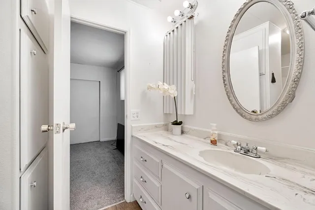 a bathroom with a granite countertop sink and a mirror