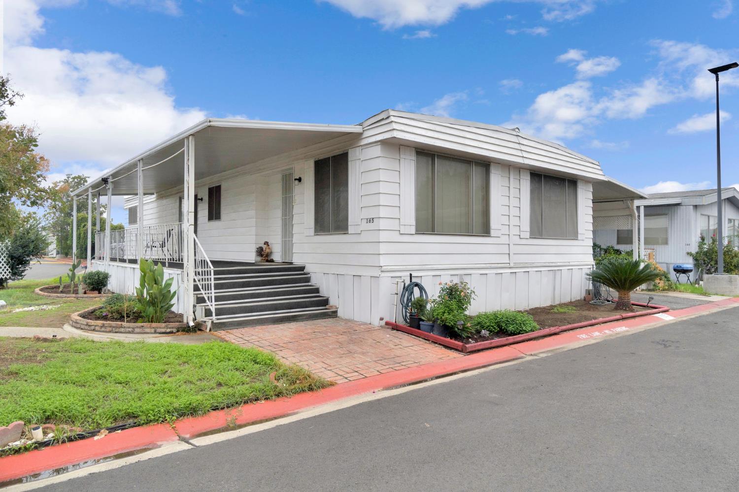 3556 North Duke Avenue, Unit 165 Fresno, CA 93727 - Photo 2 of 25 a front view of a house with garden