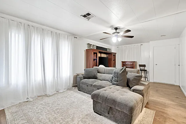 a living room with furniture and a ceiling fan
