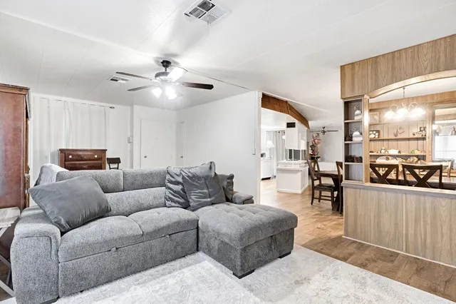 a living room with furniture and kitchen view