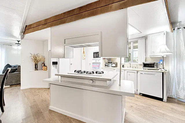 a kitchen with white cabinets and white appliances
