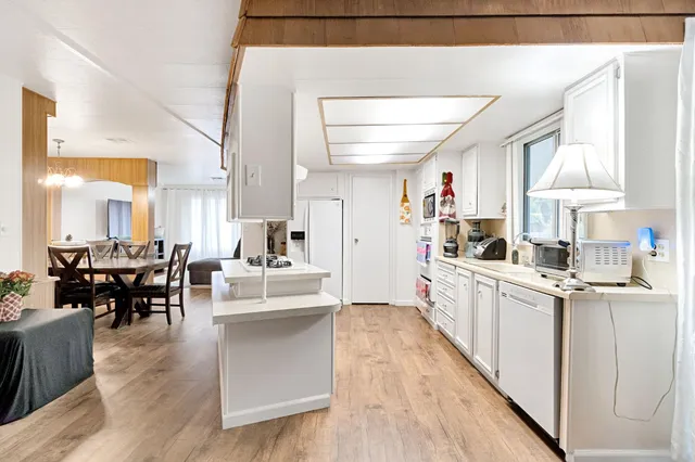 a large white kitchen with lots of counter top space and living room