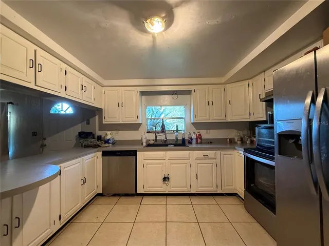 a kitchen with granite countertop a sink stainless steel appliances and cabinets