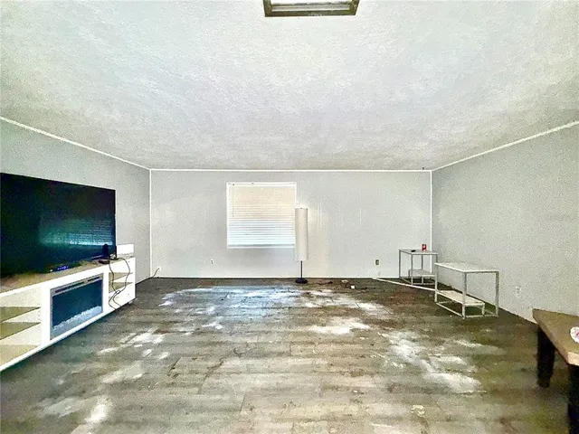 a view of a livingroom with an empty space and a window