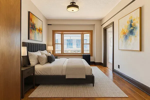 a bedroom with a bed wooden floor and window