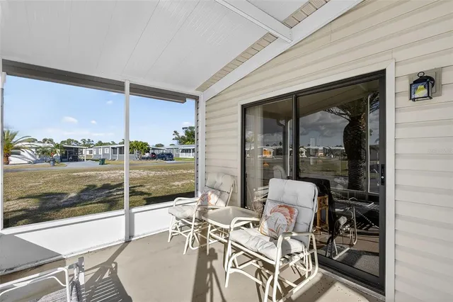 a view of a patio with table and chairs and floor to ceiling window