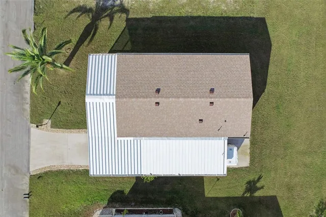 a front view of a house with a yard and potted plants