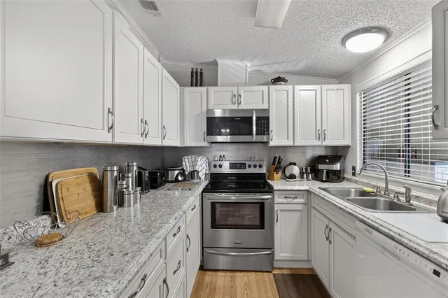 a kitchen with cabinets appliances a sink and a counter top space