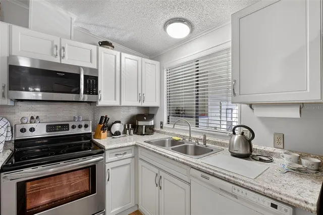 a kitchen with appliances a sink and cabinets