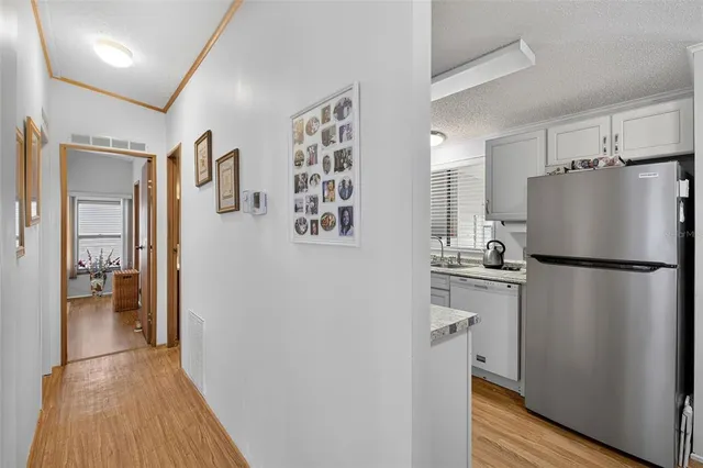 a kitchen with stainless steel appliances a refrigerator and a wooden floor