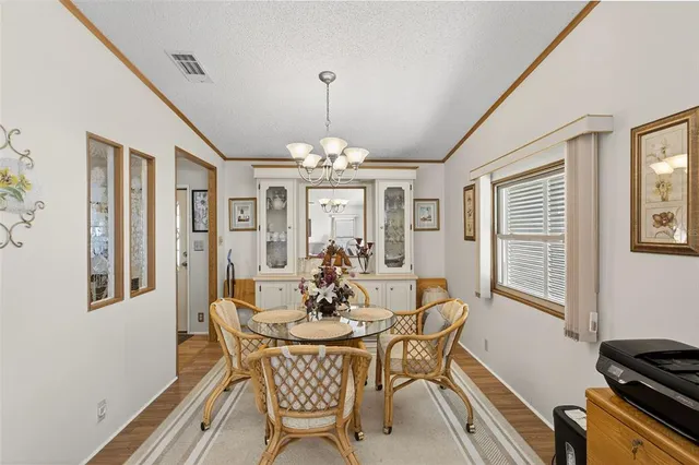 a dining room with furniture a chandelier and wooden floor