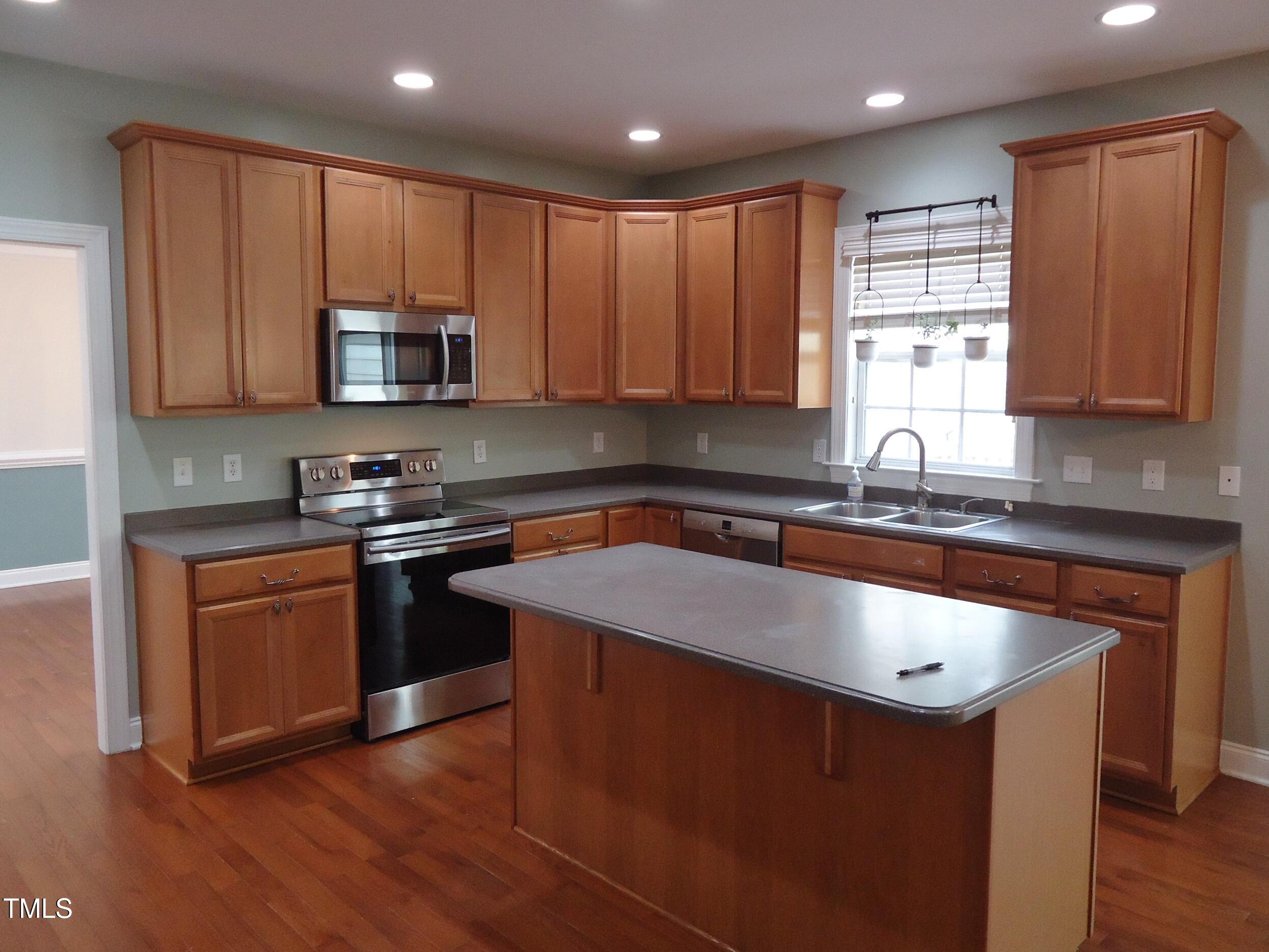 109 Bright Shade Court Holly Springs, NC 27540 - Photo 12 of 46 a kitchen with stainless steel appliances granite countertop a sink stove microwave and refrigerator