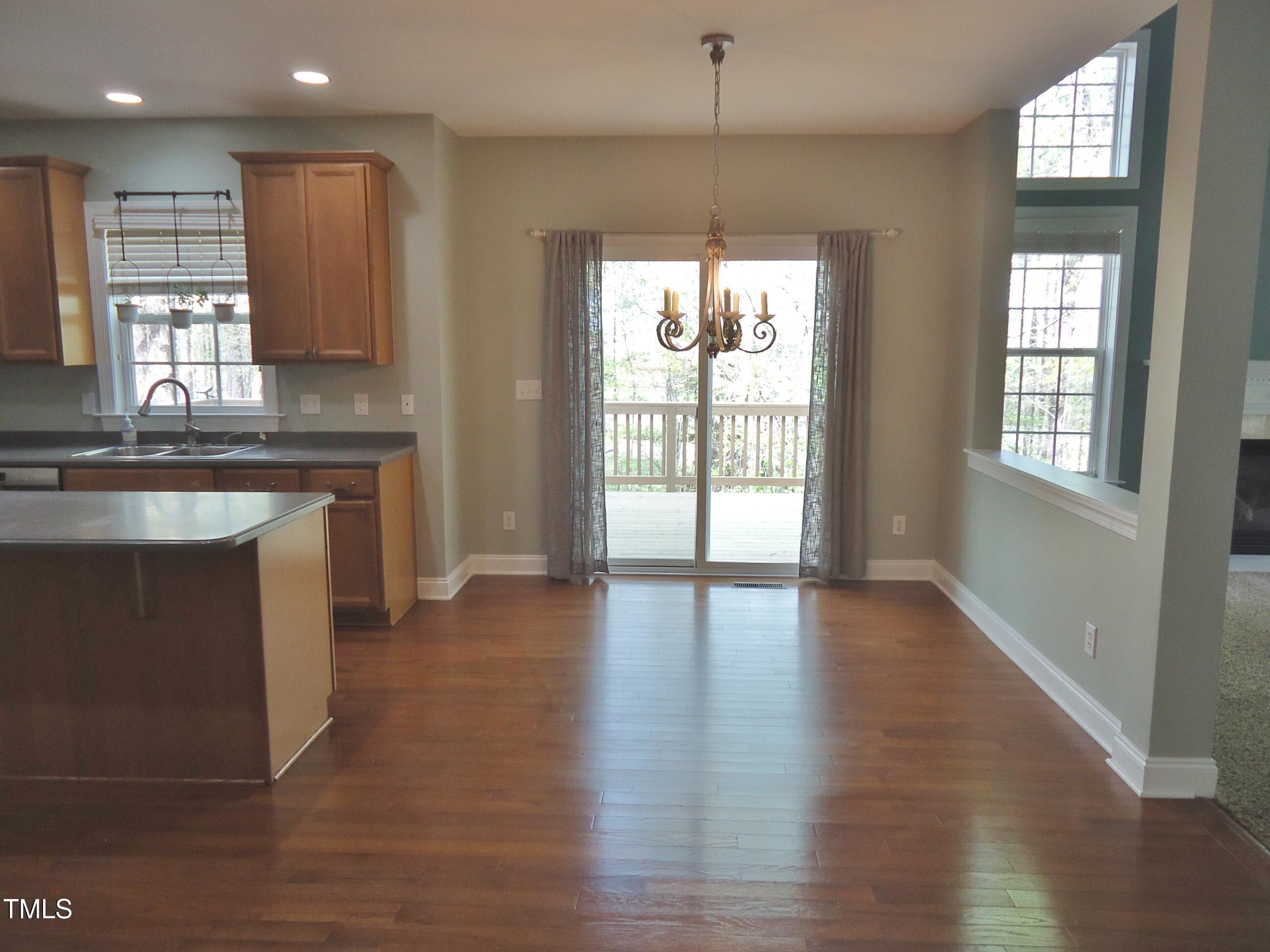109 Bright Shade Court Holly Springs, NC 27540 - Photo 17 of 46 a view of an empty room with wooden floor and a window