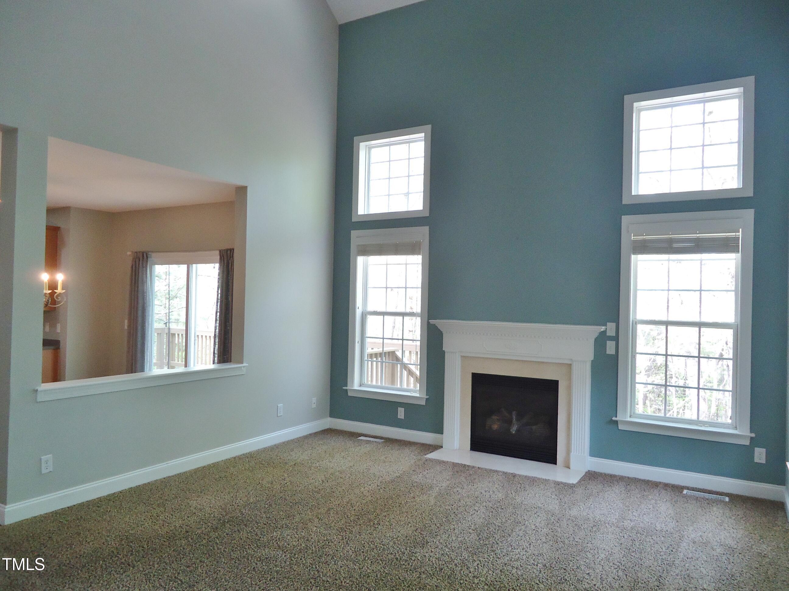 109 Bright Shade Court Holly Springs, NC 27540 - Photo 23 of 46 an empty room with windows and fireplace
