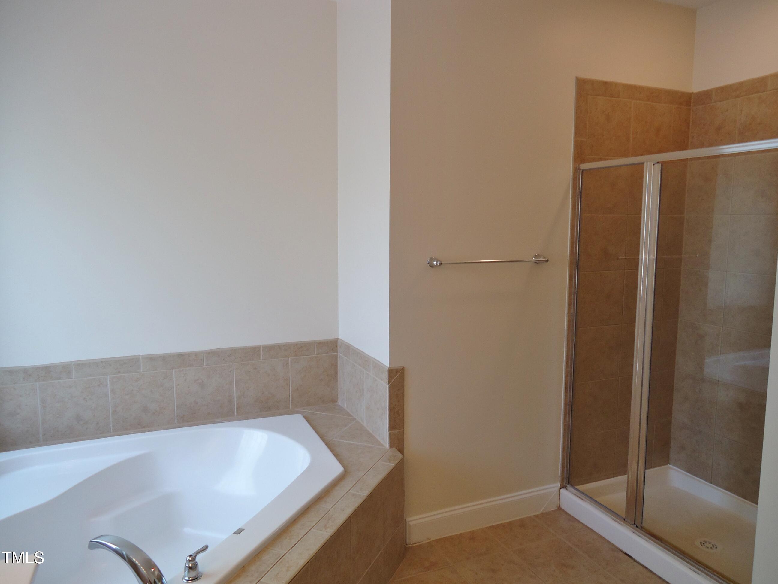 109 Bright Shade Court Holly Springs, NC 27540 - Photo 33 of 46 a bathroom with a tub and shower