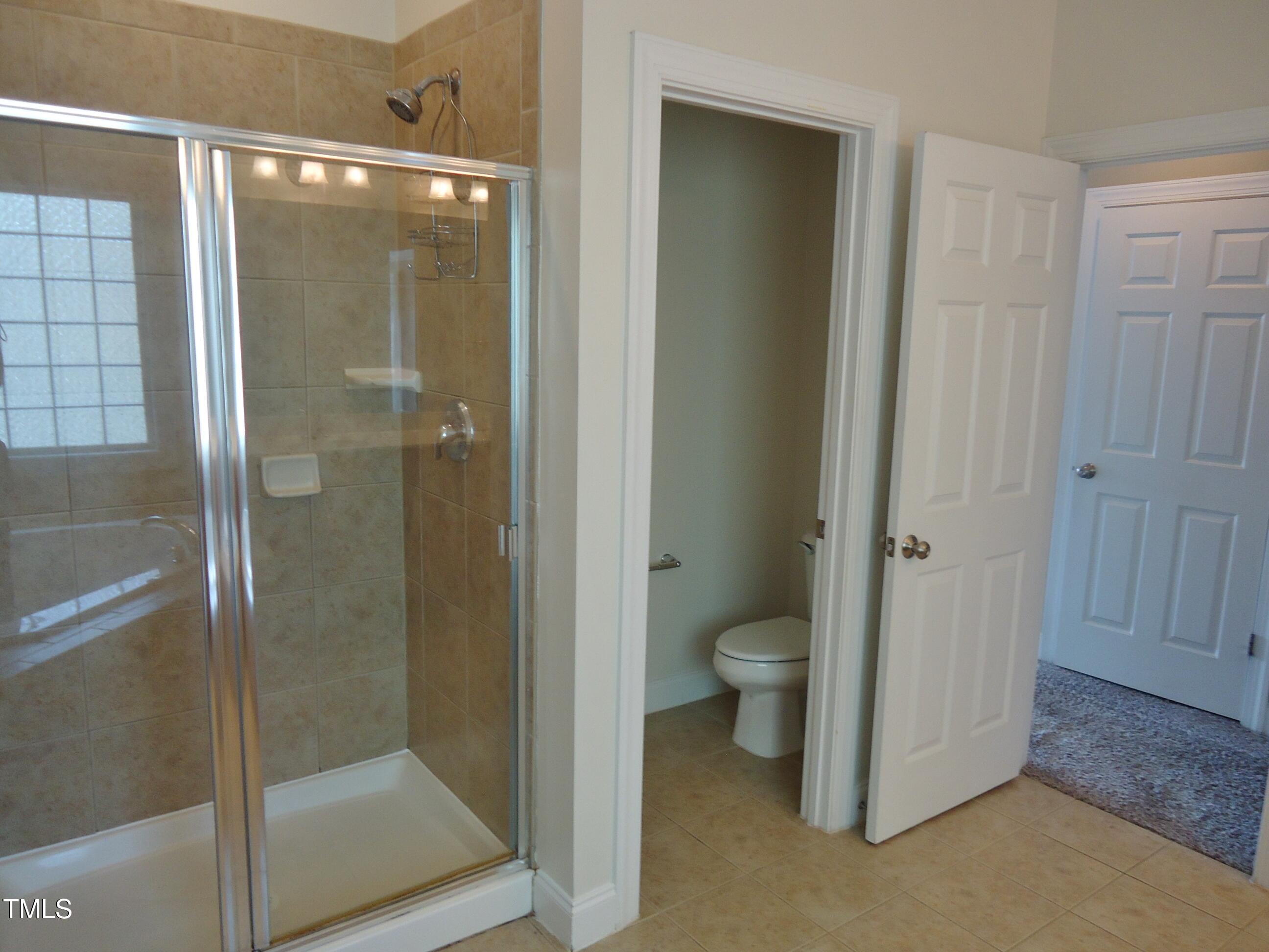 109 Bright Shade Court Holly Springs, NC 27540 - Photo 34 of 46 a bathroom with a granite countertop toilet and a shower
