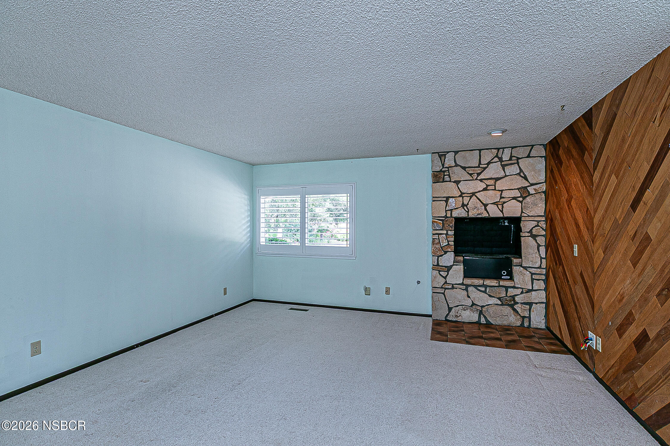 1260 Onstott Road Lompoc, CA 93436 - Photo 13 of 52 an empty room with a fireplace and natural light