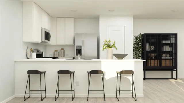 a kitchen with stainless steel appliances granite countertop a table chairs in it and wooden floors