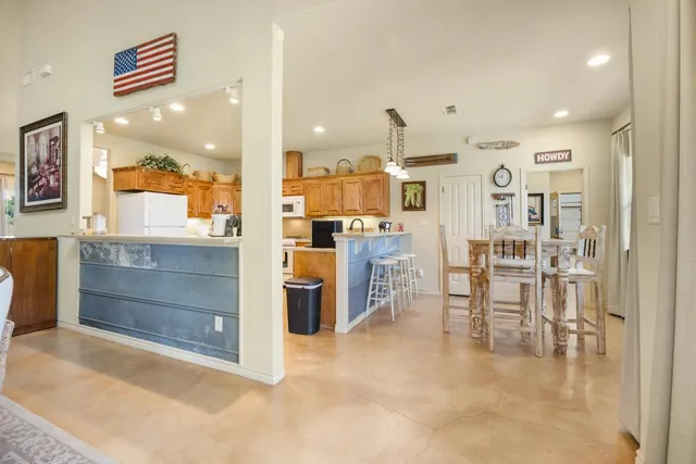 a kitchen with stainless steel appliances kitchen island granite countertop a refrigerator and cabinets