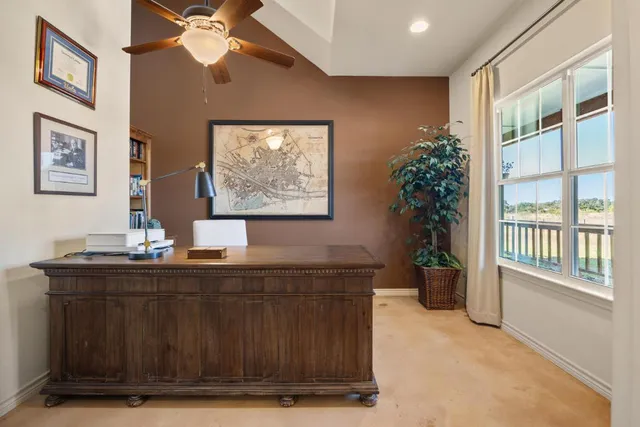 a view of a workspace with furniture and a window