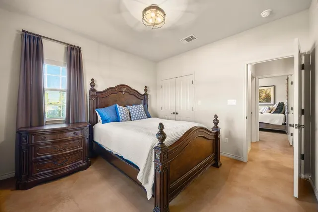 a spacious bedroom with a bed and a chandelier