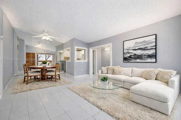 a living room with furniture and a dining table with kitchen view
