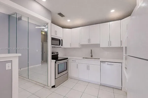 a kitchen with white cabinets stainless steel appliances and a sink