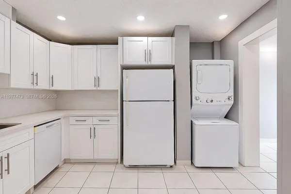 a kitchen with a refrigerator a sink and cabinets