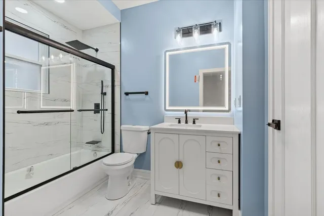 a bathroom with a toilet a sink and glass door