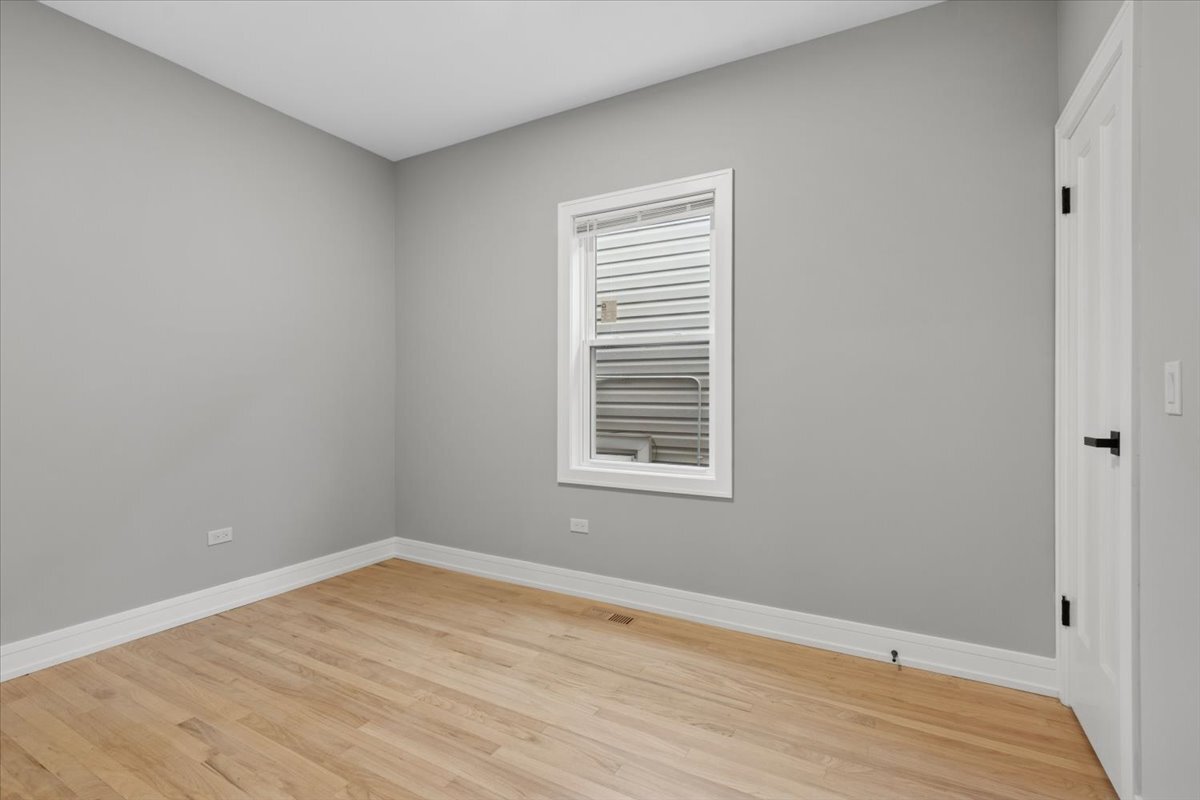 2159 North Parkside Avenue Chicago, IL 60639 - Photo 15 of 23 a view of an empty room with wooden floor and a window